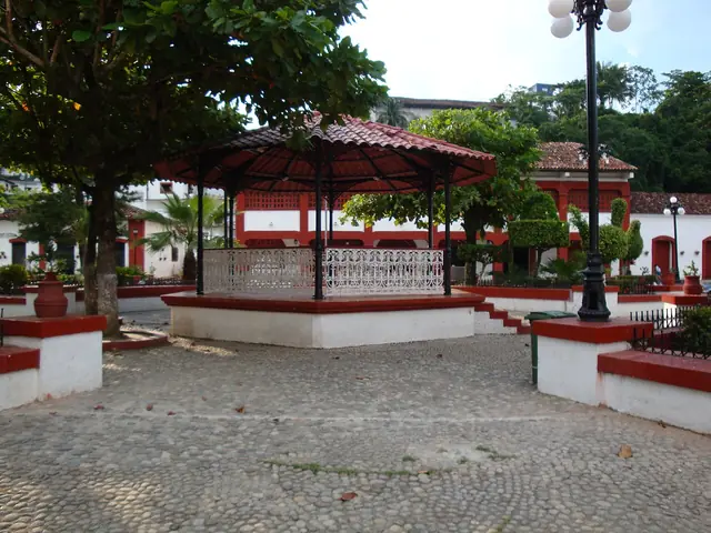 Parque de Tapijulapa con árboles y casas de techos de teja.