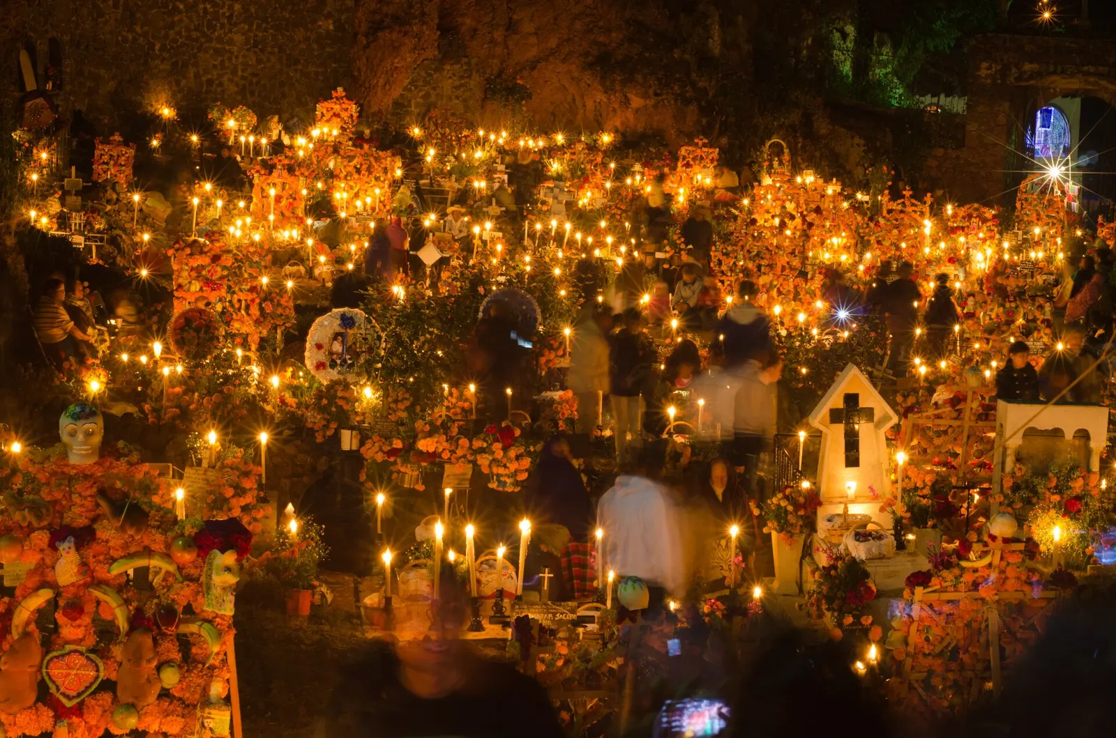 Panteón de Janitzio iluminado con velas y flores de cempasúchil durante la Noche de Muertos